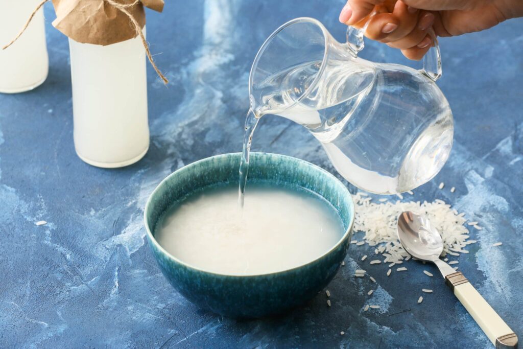 bowl of rice with water being poured in from a pitcher
