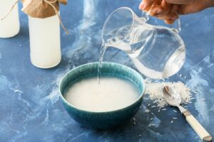 bowl of rice with water being poured in from a pitcher